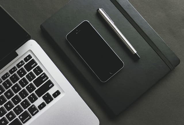 Workspace with notebook, phone, and laptop